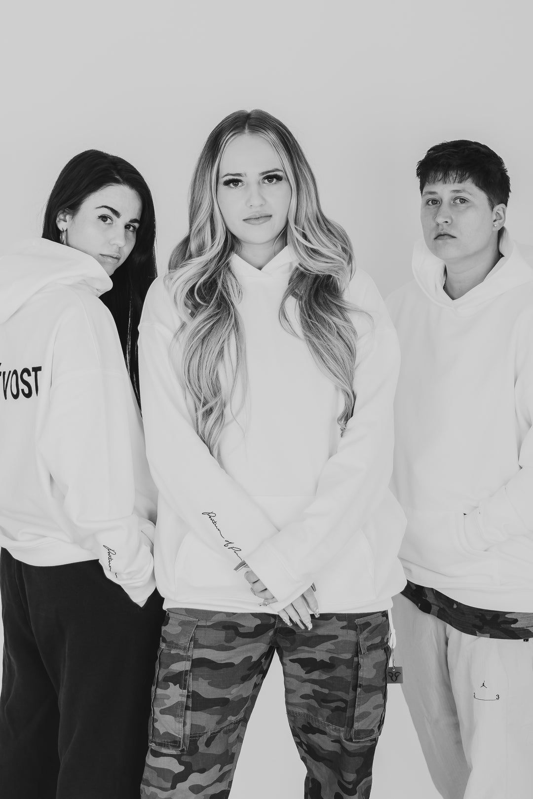 3 female fashion designers standing in front of white background with streetwear outfits